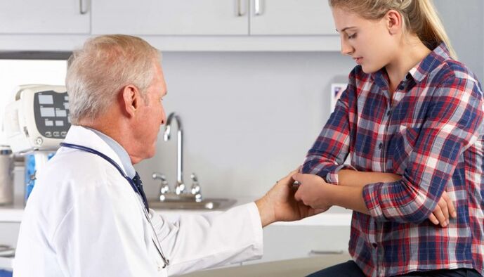 O médico examina as articulacións das mans para detectar dor